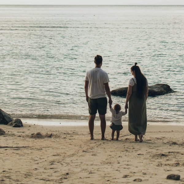 A family enjoys a tranquil day at the beach, highlighting togetherness and love.