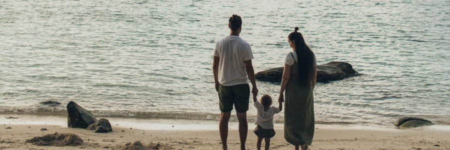 A family enjoys a tranquil day at the beach, highlighting togetherness and love.